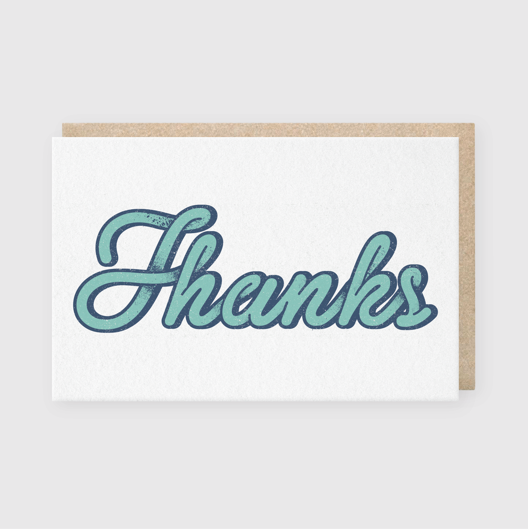 The Thanks Bubble Type Greeting Card features "Thanks" in an elegant blue script on a simple light gray background. Crafted with premium letterpress techniques, this card is hand printed in Seattle, offering a charming and sophisticated design.