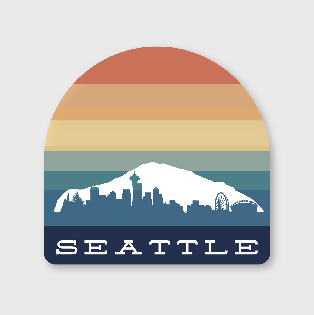 The Seattle Sunset Arch Sticker is a die-cut vinyl sticker featuring a stylized depiction of Seattle's skyline. It includes the iconic Space Needle and a Ferris wheel in white, set against a vibrant gradient background of orange, yellow, green, teal, and blue stripes. Crafted by artists to withstand weather conditions, it prominently displays "Seattle" at the bottom.