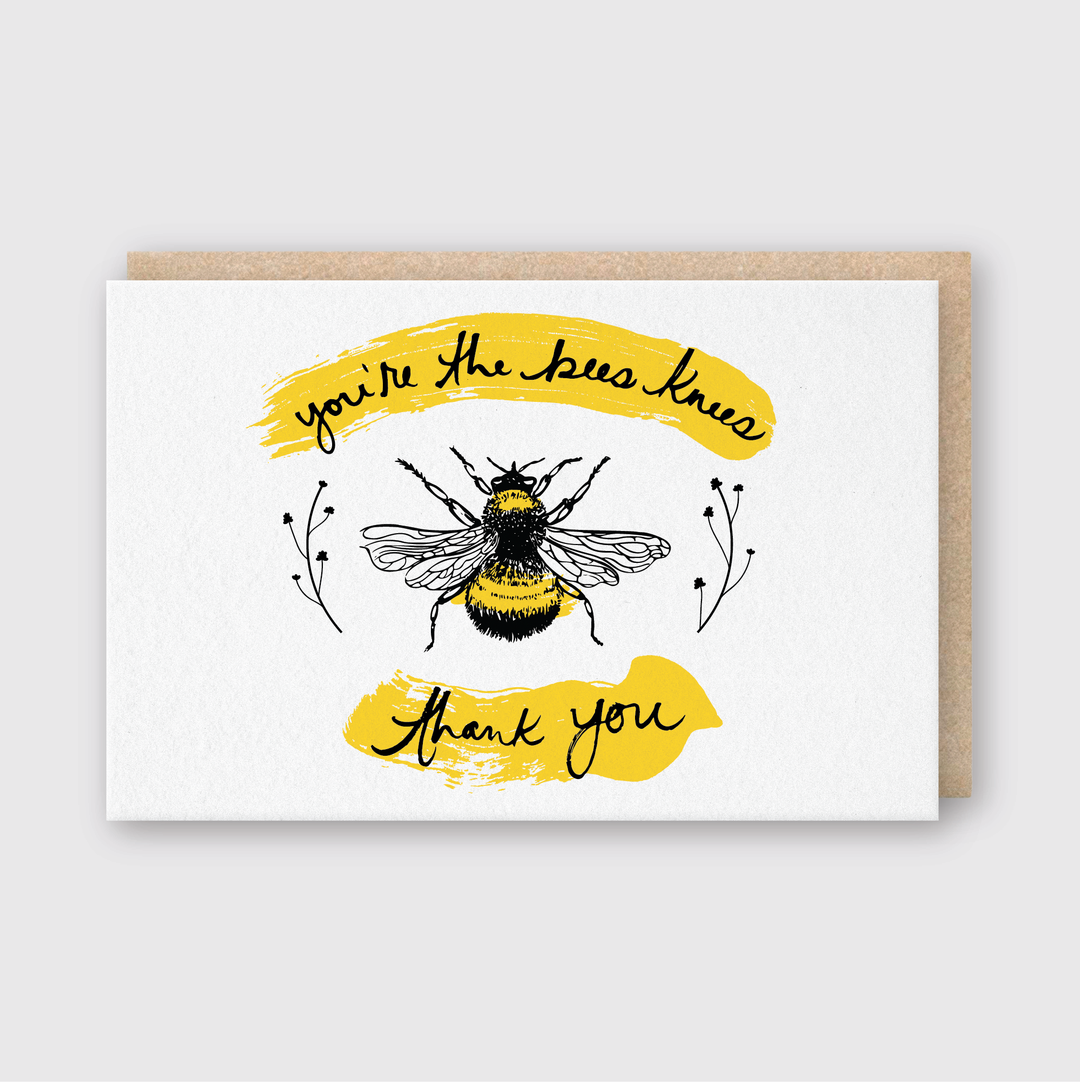 This greeting card features a charming bee illustration alongside the phrase "you're the bees knees, thank you." It showcases exquisite letterpress techniques, highlighting its yellow and black design on a white background. The card comes with a brown envelope and is handcrafted for a personal touch.