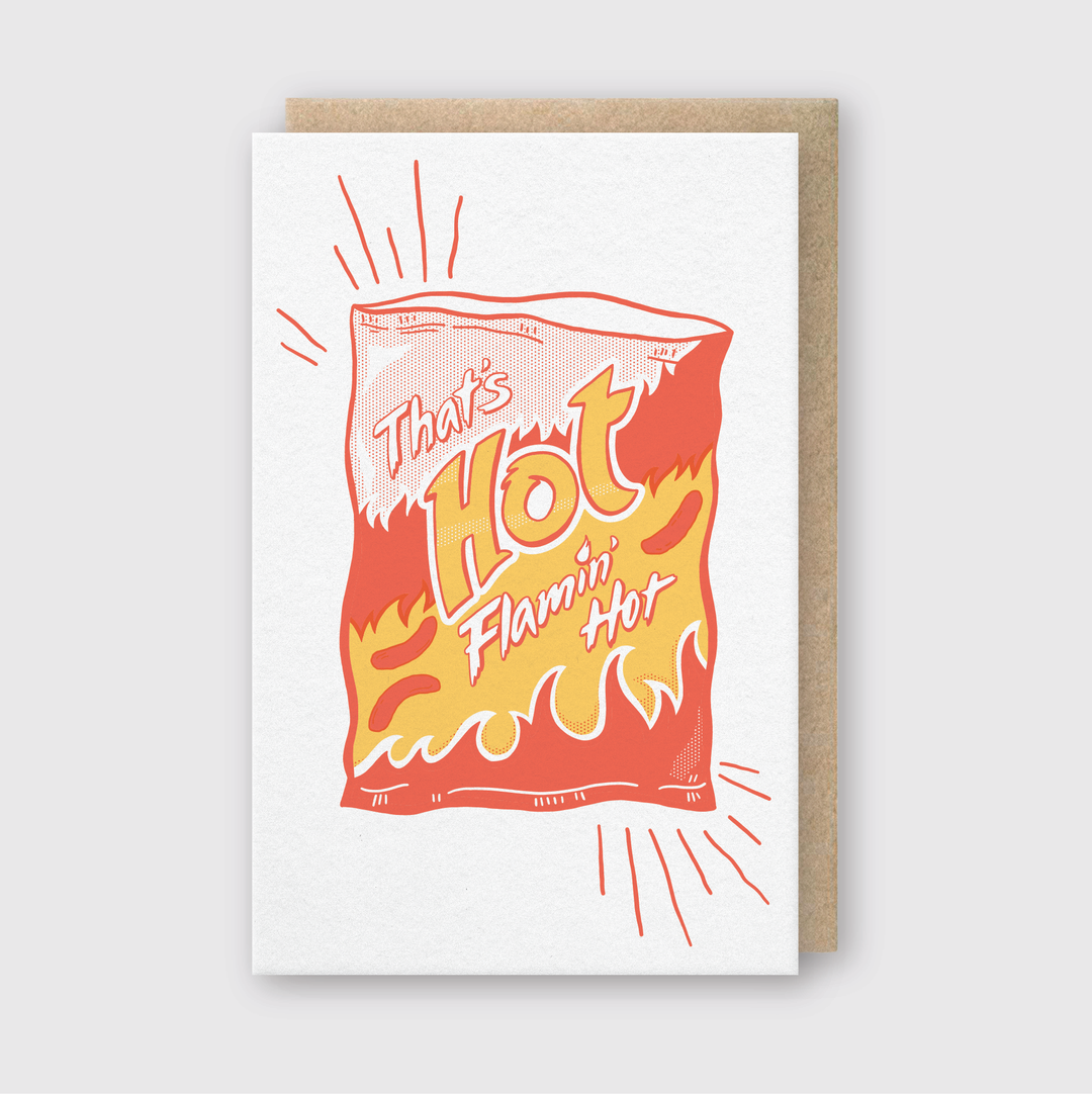 The "That's Hot" Greeting Card features an illustrated snack bag with flames and bold "That's Hot Flamin' Hot" text. Crafted by hand in Seattle, this card boasts a striking red, yellow, and orange design set against a simple backdrop. It comes with an eco-friendly Recycled Kraft Envelope.