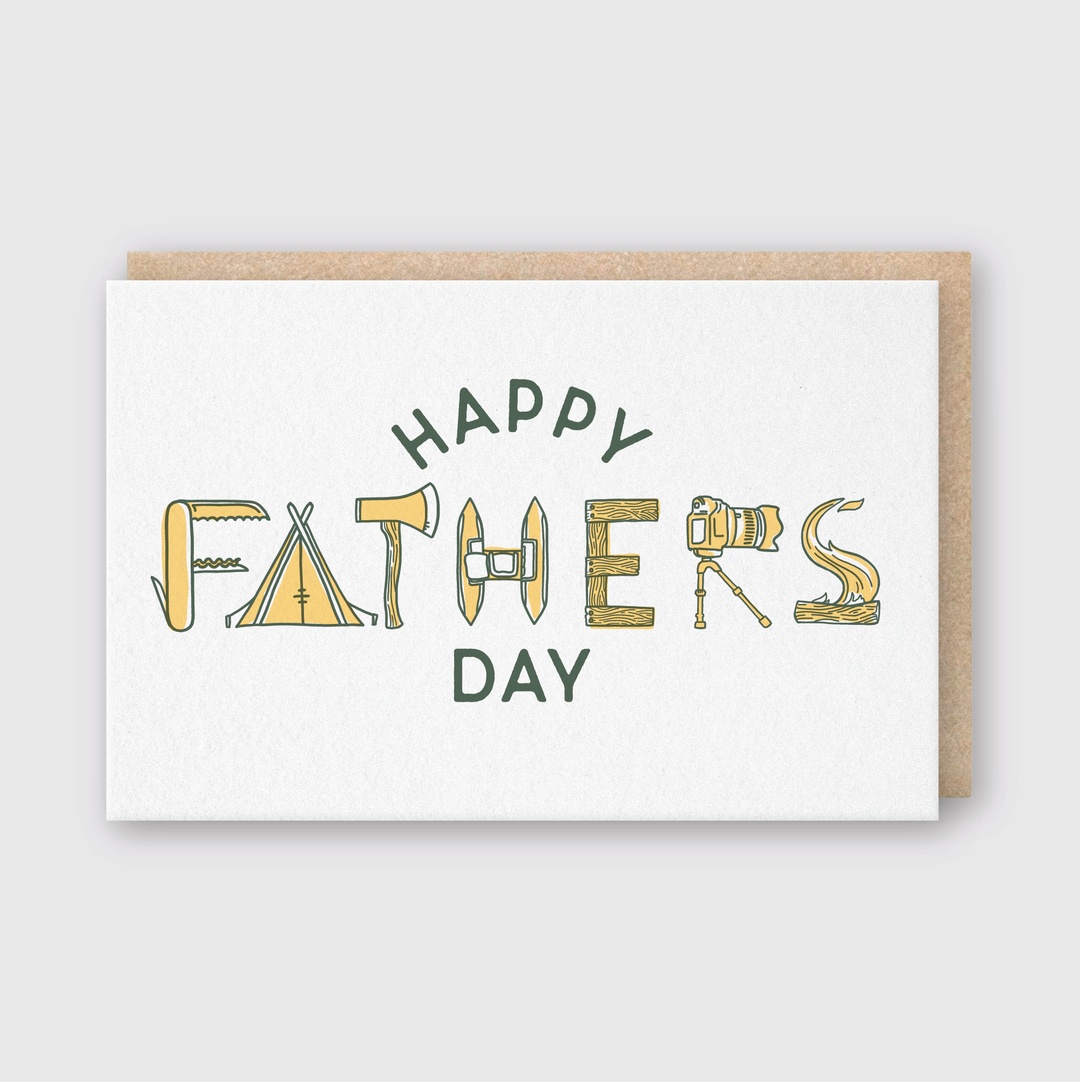 The Father's Day Outdoors Greeting Card features the words "HAPPY FATHERS DAY" using outdoor-themed letters, incorporating elements like tents and fishing rods. Made from FSC Certified Paper, this card displays earthy tones against a crisp white background, perfect for dads who enjoy the outdoors.