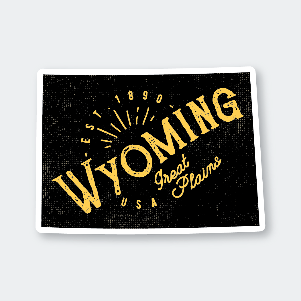 The Wyoming #1 Sticker is a black, weather-resistant, die-cut vinyl sticker. It displays bold yellow text reading "Wyoming USA," with "Est 1890" above and "Great Plains" below in a script font. The design is complemented by a sunburst motif.