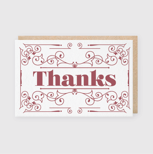 Introducing the 'Thanks Maroon Card Greeting Card': This meticulously crafted card showcases an exquisite maroon border surrounding the word "Thanks" in prominent red letters on a pristine white background. The card is slightly open with a classy brown envelope nestled beneath, emanating elegance and personal charm.