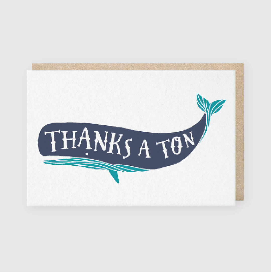 This description highlights a greeting card featuring the "Thanks a Ton Whale" by Pike Street Press. The illustration cleverly integrates text into the whale's shape, offering a clean and playful look with calming blue hues. It comes with a natural brown envelope and is hand-printed in Seattle.