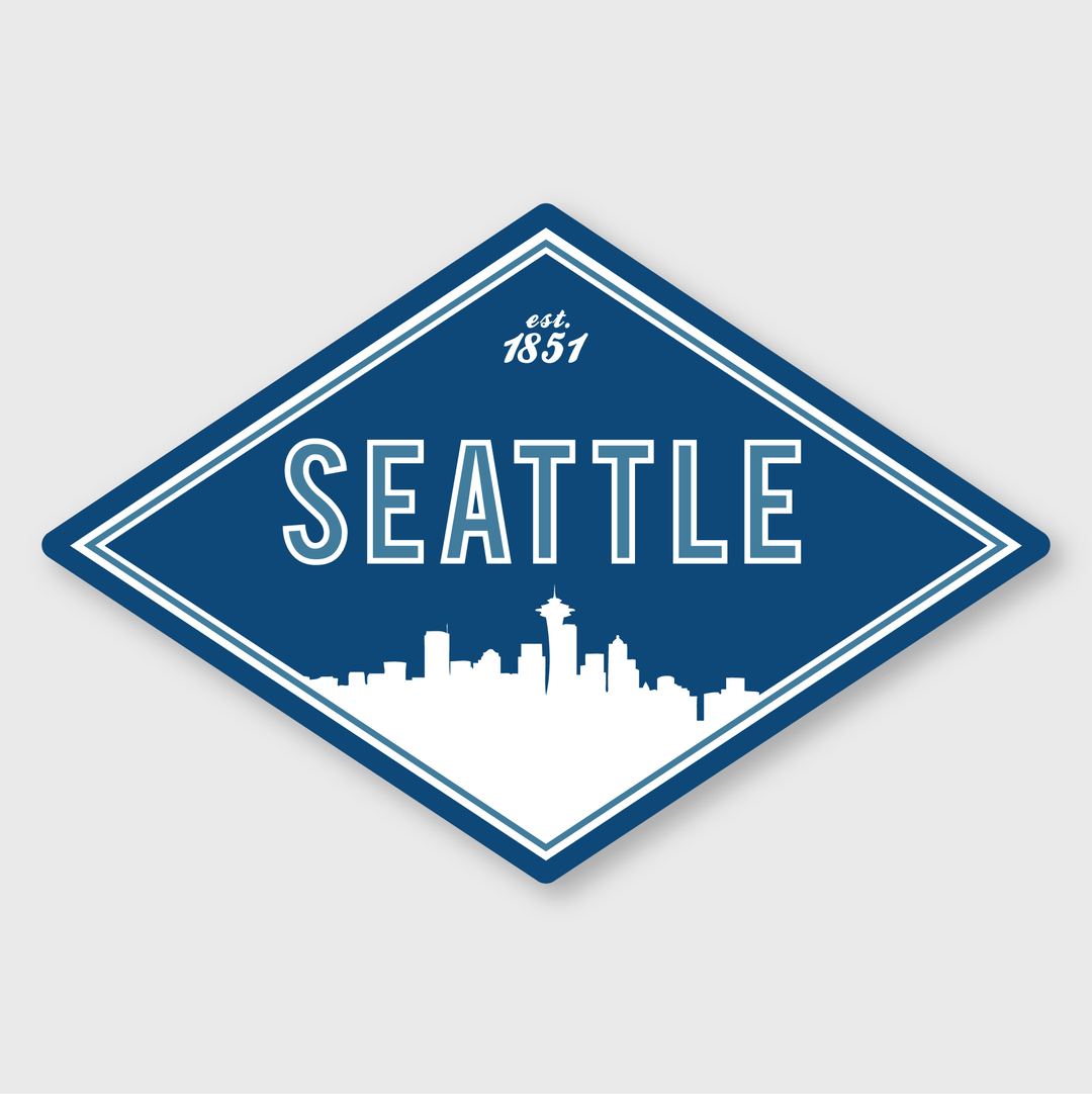 The "Seattle Diamond Sticker" features a striking blue diamond design with bold white "Seattle" lettering above a silhouette of the city’s skyline, complete with the iconic Space Needle. The text "est. 1851" is displayed at the top. Carefully crafted as a die cut vinyl sticker, it showcases the creativity of talented artists.