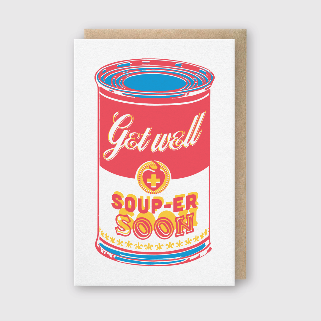 The Souper Soon Greeting Card features a vibrant illustration of a soup can with the phrases "Get well" and "Soup-er soon" in retro-style letters. The red, yellow, and blue can stands out against a light grey background, making it an ideal choice for wishing someone a speedy recovery.