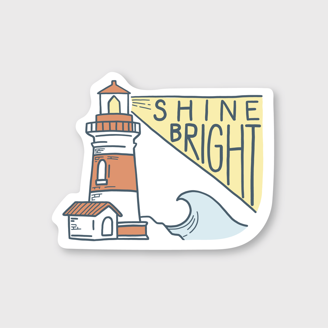 The Shine Bright Lighthouse Sticker from Pike Street Press showcases a lighthouse beacon illustration with the phrase "Shine Bright" in yellow, set against waves. It is made from durable vinyl, offering weather resistance, and has a light gray background.