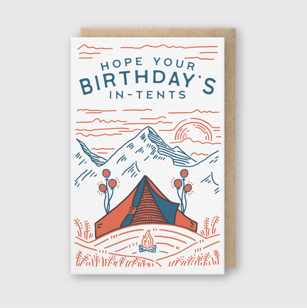 The In Tents Birthday Greeting Card is a charming option for camping enthusiasts, featuring the playful phrase "Hope your birthday's in-tents." The card is beautifully illustrated with a tent, campfire, and towering mountains in blue and red lines.
