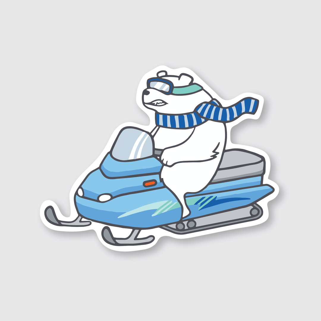 Here is a description of the Snowmobile Polar Bear Sticker: This sticker features a polar bear wearing goggles and a blue-striped scarf, skillfully riding a blue snowmobile against a white background. It is made from weather-resistant die-cut vinyl for durability.