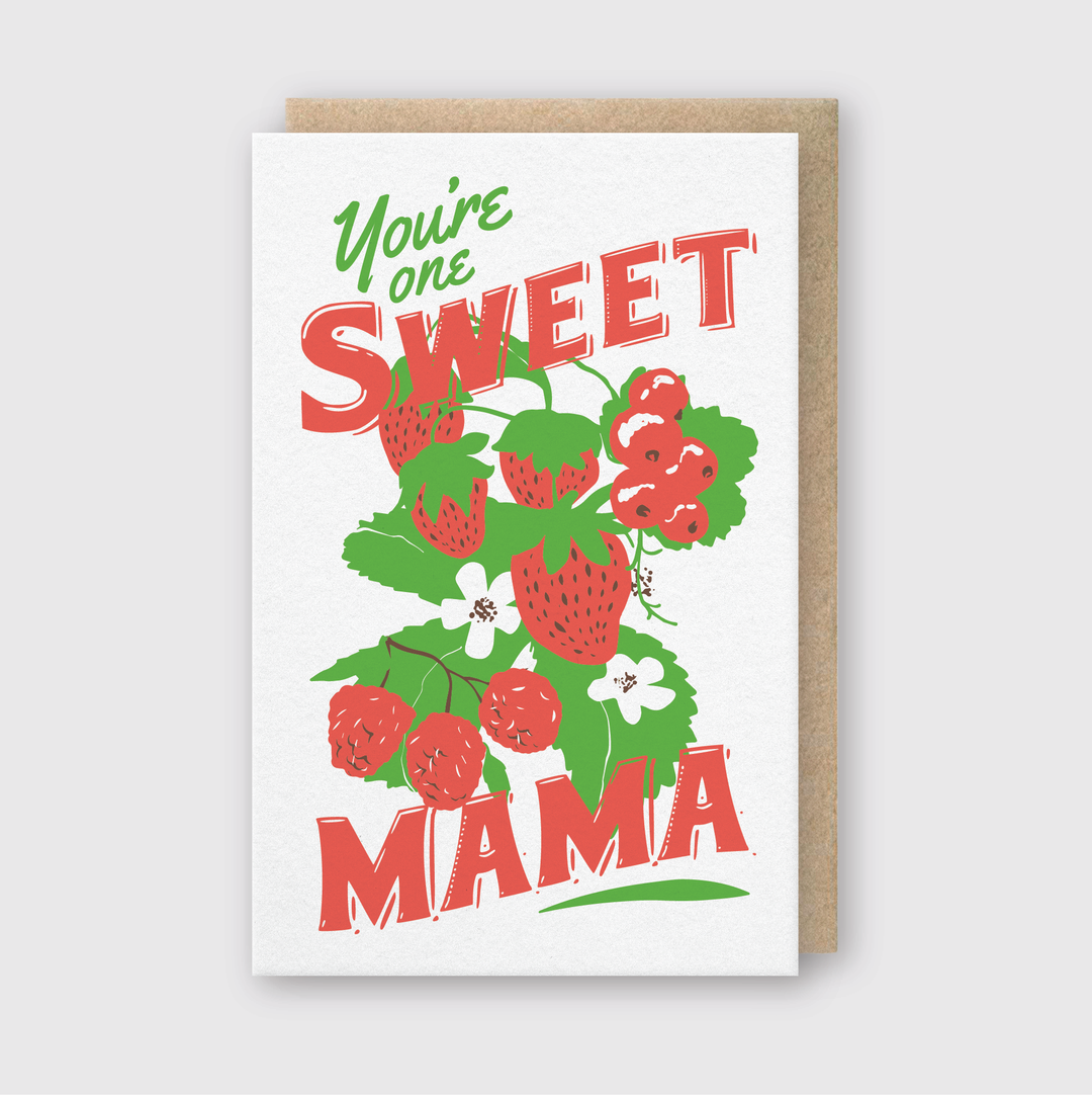 The "You're One Sweet Mama Greeting Card" features the lively text "You're one SWEET MAMA" in red and green. It includes illustrations of strawberries and raspberry clusters, adorned with green leaves and white flowers. Handcrafted in Seattle, this card comes with a plain brown envelope.