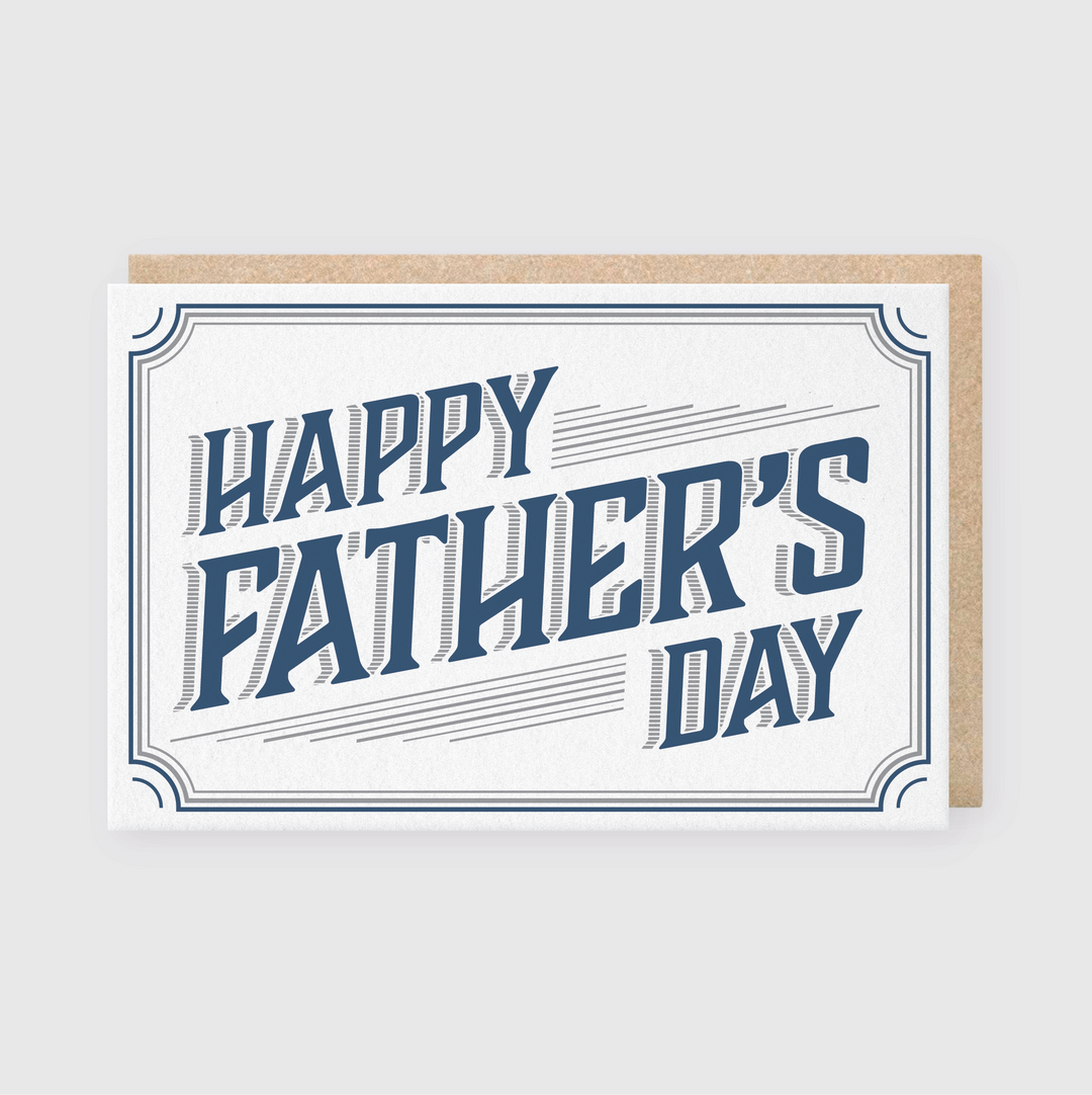 The Father's Day Border Greeting Card features "Happy Father's Day" in bold, blue letters crafted using traditional letterpress techniques. This minimalist design is complemented by a brown envelope peeking from behind.