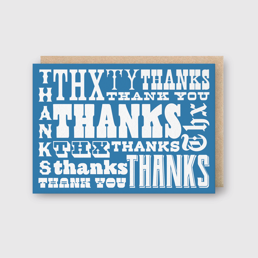 The Thanks Type Greeting Card presents a blue cover with "thanks" artfully arranged in diverse fonts and sizes in crisp white text. Handcrafted with care in Seattle, it employs premium letterpress techniques for a unique way to convey your heartfelt gratitude.