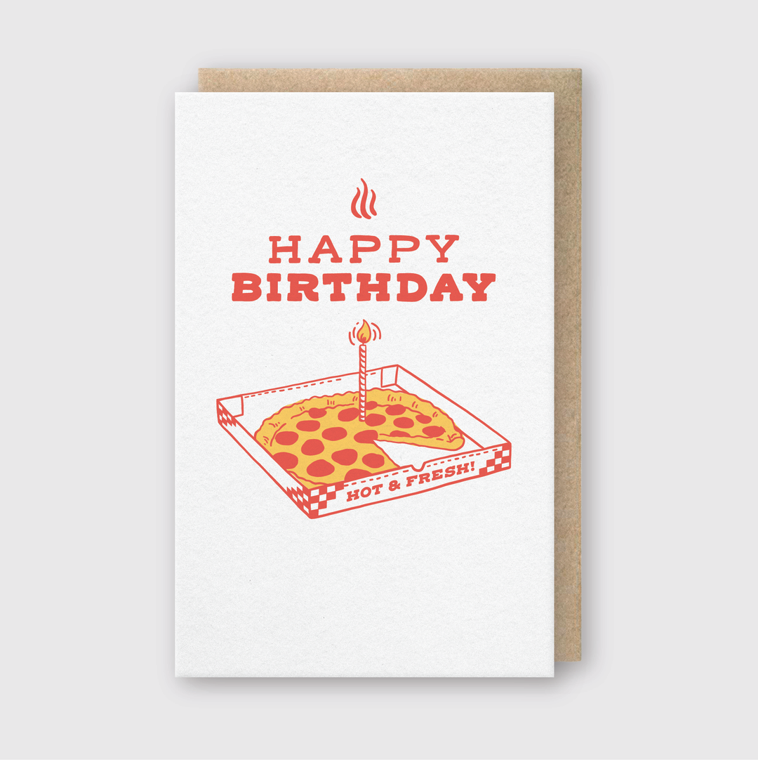 A Pizza Birthday card features a slice of pizza topped with a lit candle, presented in a box. The greeting "HAPPY BIRTHDAY" is highlighted in bold red. This card is crafted by hand in Seattle on FSC Certified Paper, with the pizza box declaring "HOT & FRESH!