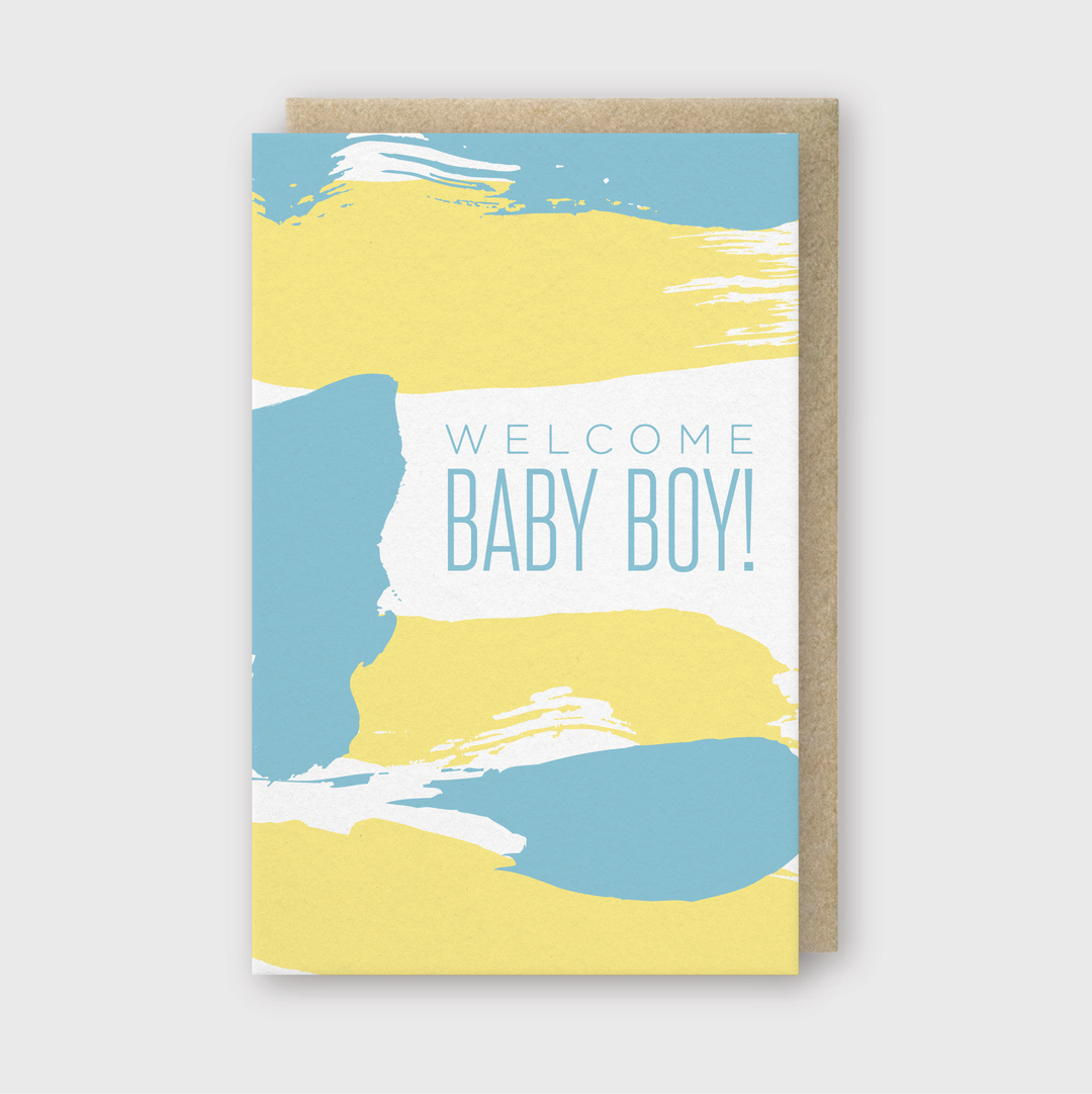 The "Welcome Baby Boy Greeting Card" features blue and yellow abstract brush strokes along with the phrase "Welcome Baby Boy!" It comes with a brown envelope and is set against a light background, making it perfect for celebrating a new arrival.