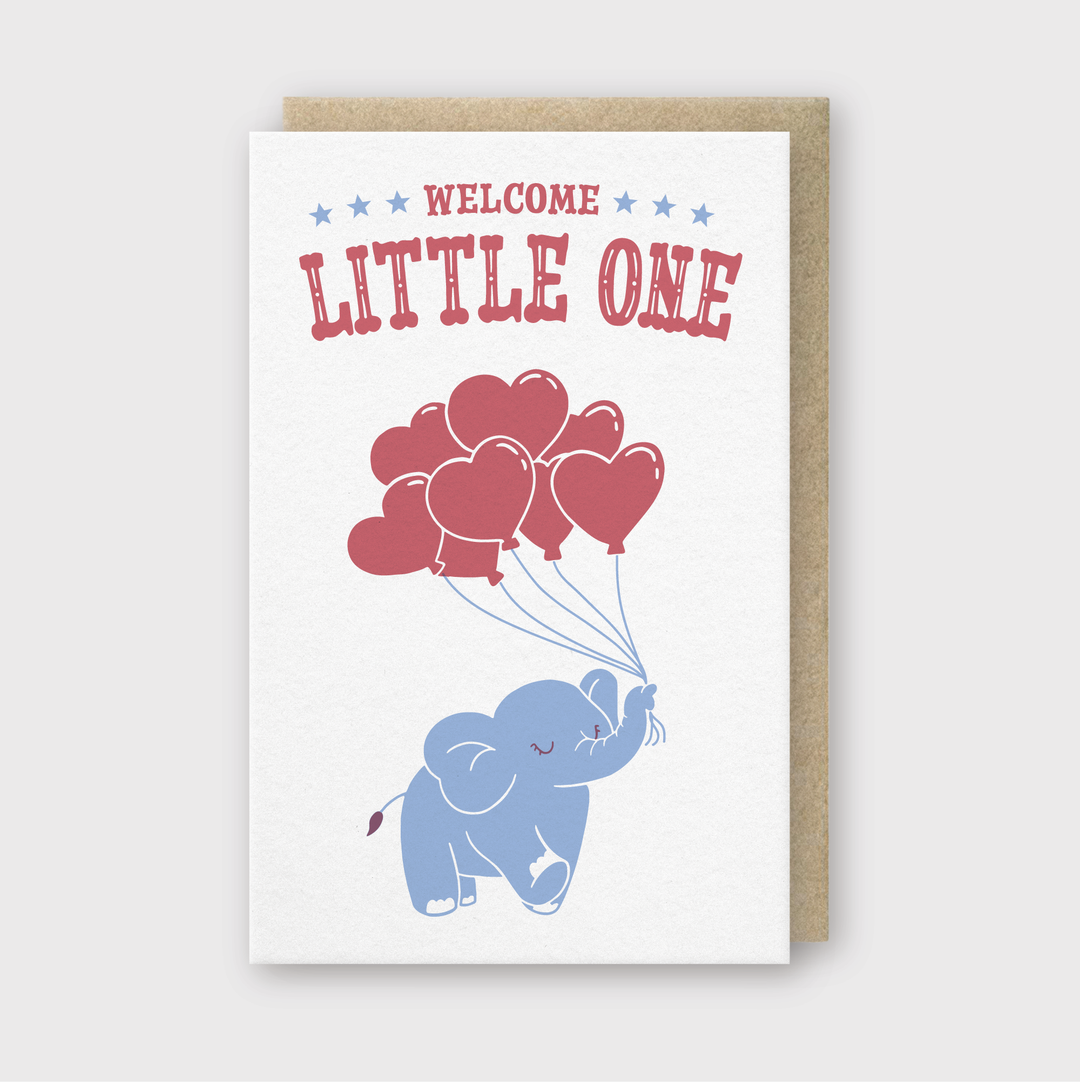 Introducing the "Welcome Little One" Greeting Card: This delightful letterpress card features a blue elephant elegantly holding red heart-shaped balloons. Accented with shimmering red "Welcome Little One" text and blue stars, it exudes minimalist elegance. The card is paired with a sophisticated brown envelope.
