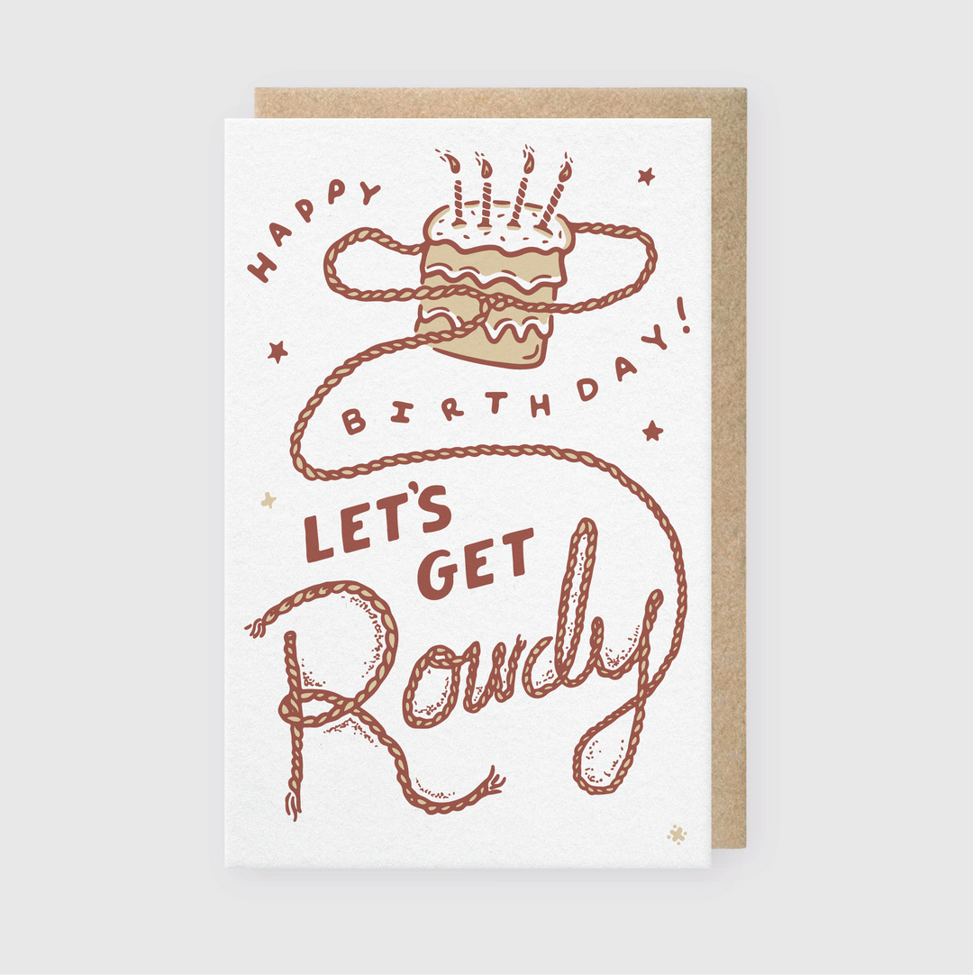 The "Let's Get Rowdy Birthday" card features an illustrated cake with lit candles and a rope-like "Happy Birthday! Let's Get Rowdy" message. Handcrafted in Seattle, it includes a brown border and is printed with environmentally-friendly soy-based inks for a sustainable finish.