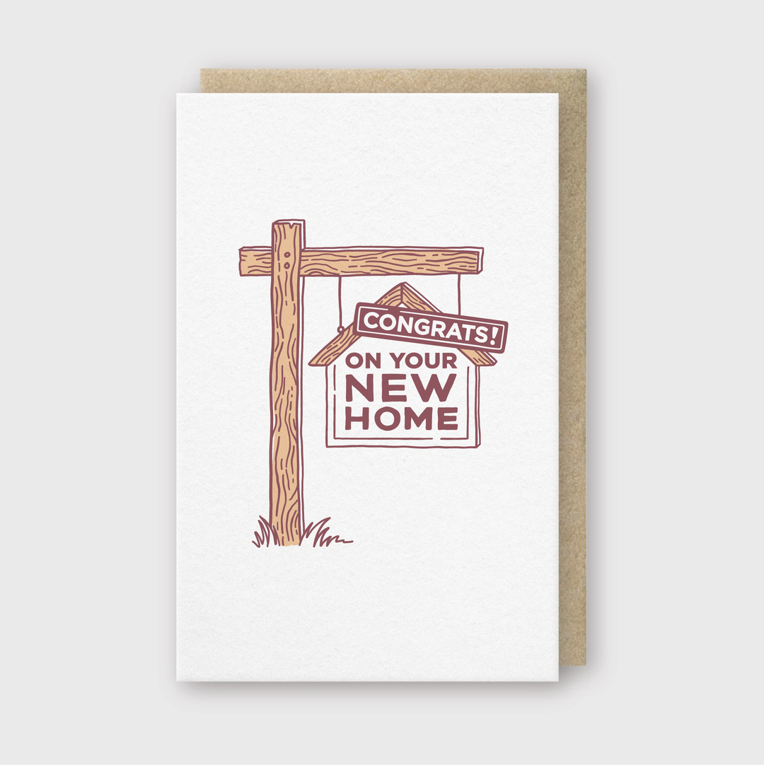 The New Home Sign Greeting Card is a charming way to celebrate someone’s new home. It features an illustration of a wooden post with a sign that reads, "Congrats! On your new home." This card comes with a brown envelope and its minimalist design makes it perfect for conveying heartfelt congratulations.