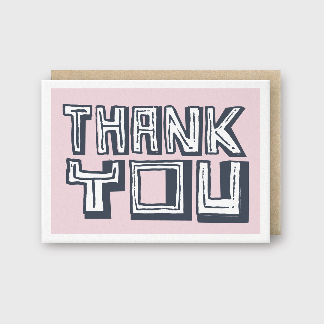 The Thank You Pink Block Type Greeting Card is a beautifully handcrafted piece from Seattle, featuring "Thank You" in bold, stylized letters on a pink background. It is elegantly paired with a brown envelope and showcases exquisite letterpress printing.