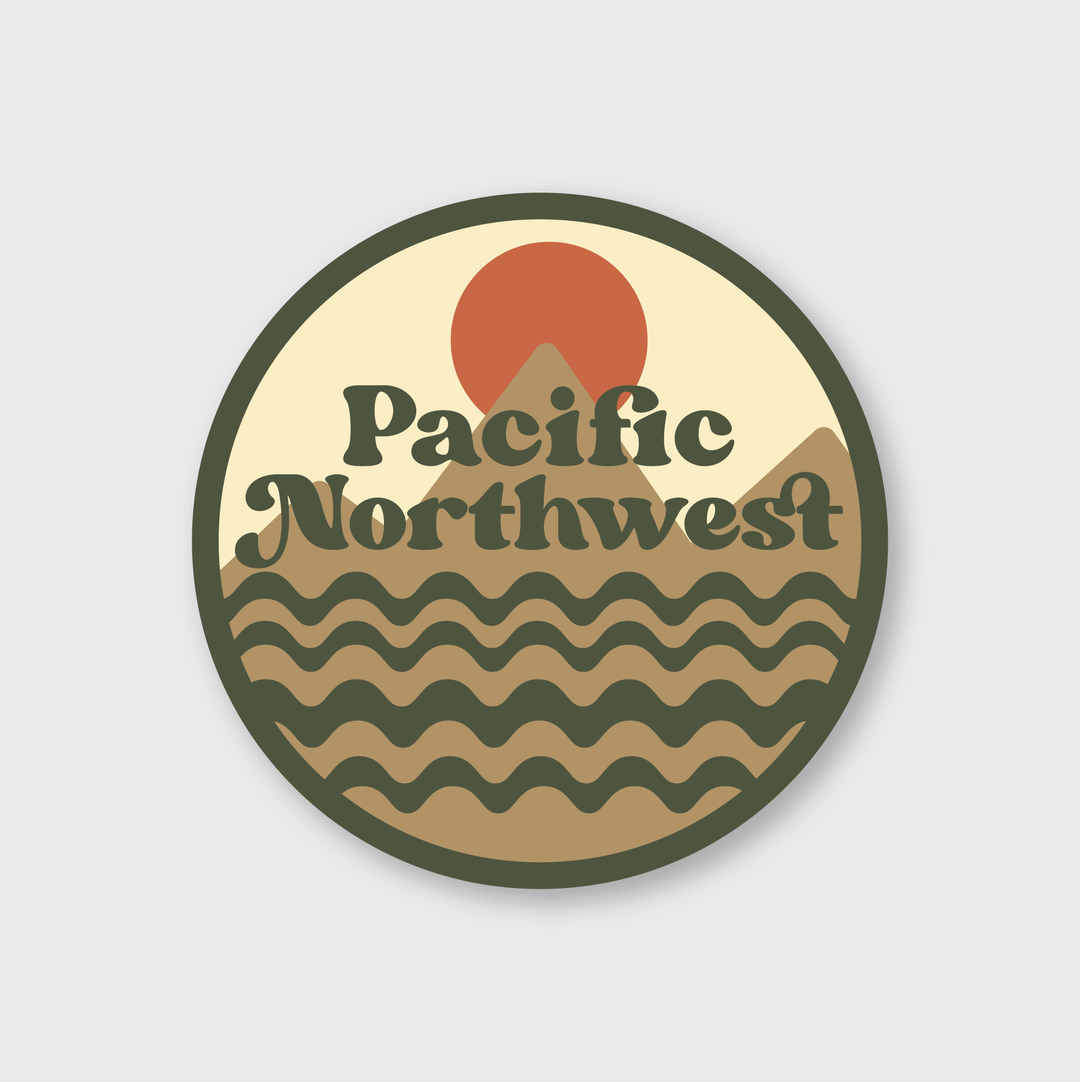 The Earthy PNW Sticker is a circular design that highlights stylized waves and mountains beneath a red sun. Handcrafted in Seattle, it prominently displays "Pacific Northwest" in a retro-style font. The die-cut vinyl sticker features earthy tones, including olive green, brown, and orange.