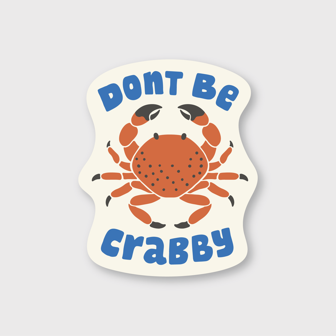 Introducing the "Don't Be Crabby Sticker": This die-cut vinyl sticker features a vivid red crab illustration front and center, surrounded by the phrase "Don't Be Crabby" in blue font both above and below. Set against a light beige background, this handcrafted piece from Seattle adds a unique touch to your collection.