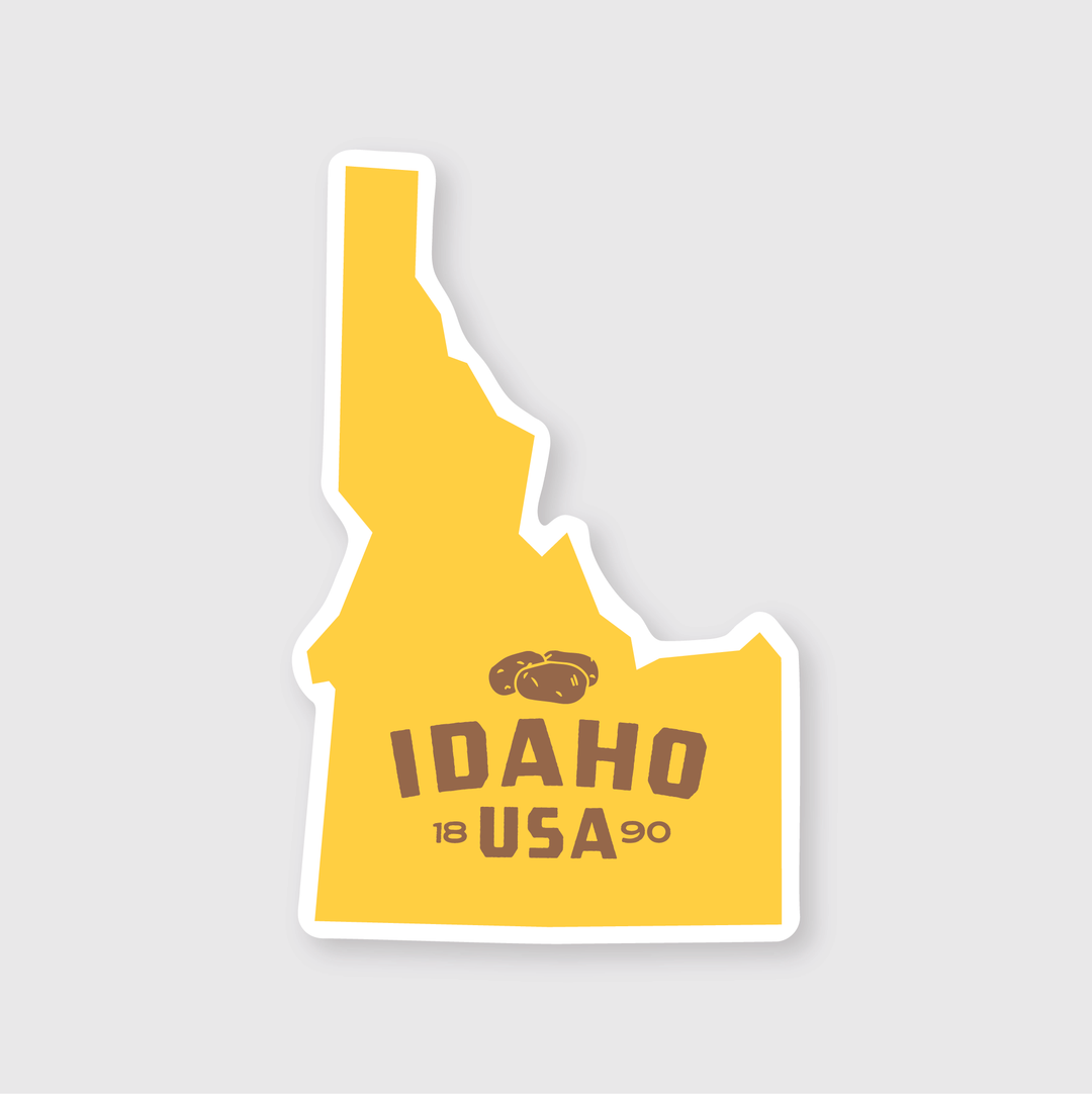 This die-cut vinyl sticker showcases a yellow silhouette of Idaho with the words "Idaho USA" and a central image of potatoes. The numbers "18" and "90" signify the state's founding year, 1890. Designed to be weather-resistant, it features a light gray background and is perfect for Idaho enthusiasts.