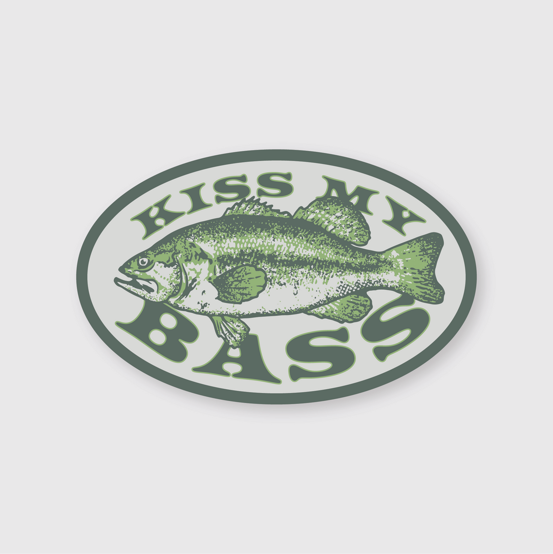 The Kiss My Bass Sticker features a fish illustration inside an oval, bordered by the phrase "KISS MY BASS." It is designed in green and gray on a white background. This die-cut vinyl sticker is weather resistant, making it suitable for outdoor use.