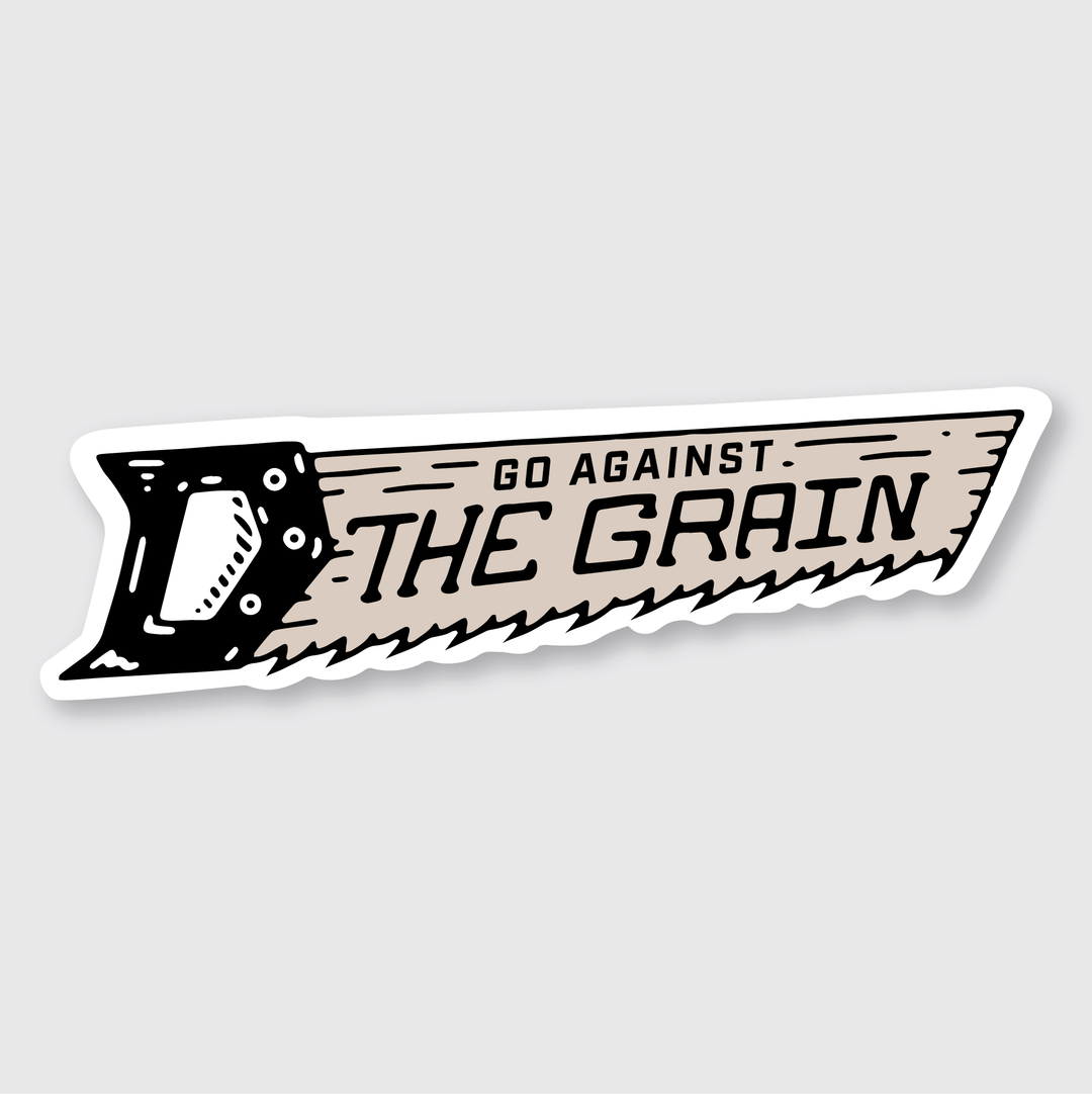 Illustration of a hand saw with the text "Go Against The Grain" on the blade. This die-cut vinyl sticker features bold black and beige hues against a spotless white background, ensuring a high-quality finish that makes it striking anywhere you display it.