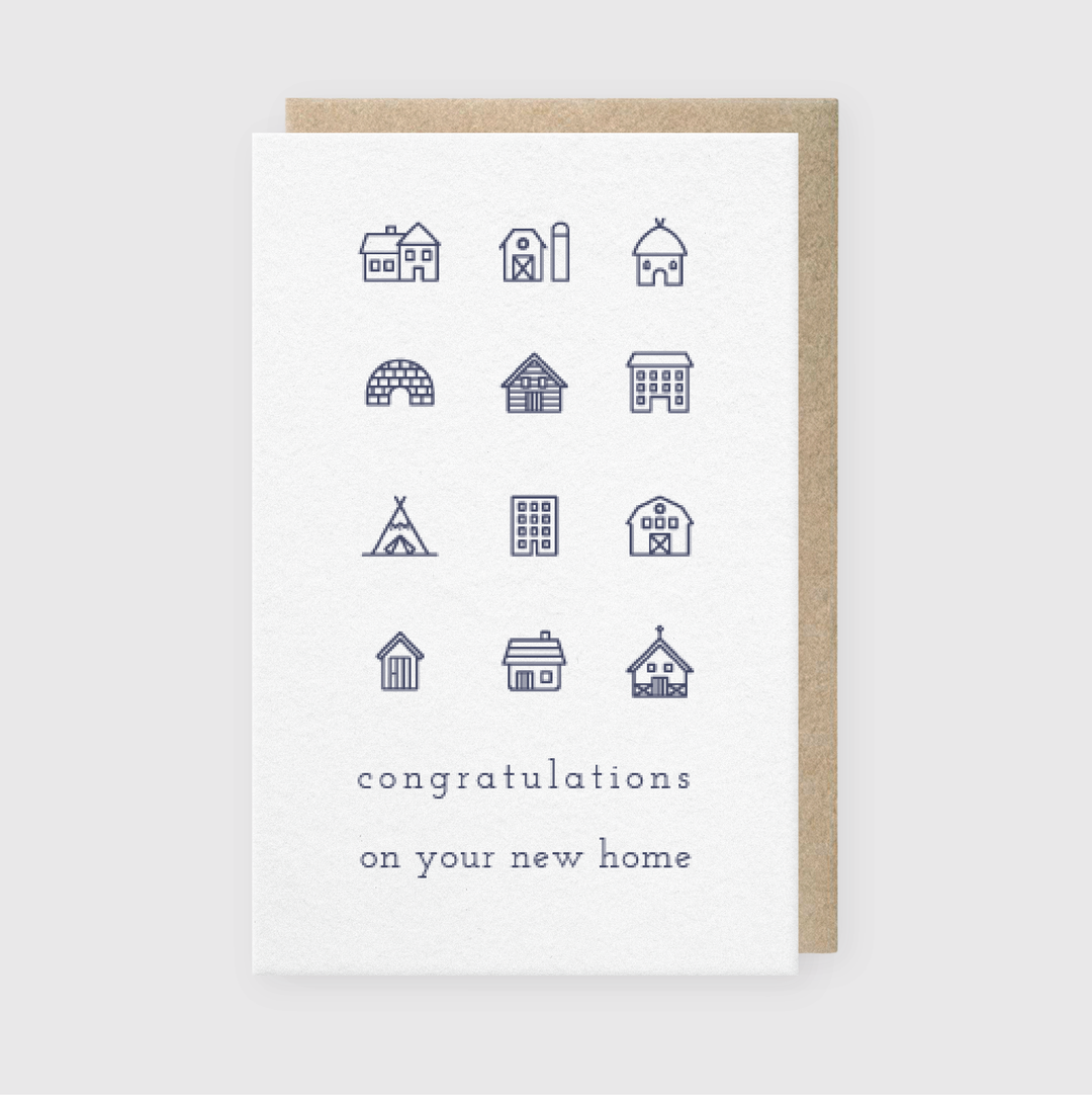 The Pike Street Press "Congrats New Home Greeting Card" showcases intricate line drawings of buildings like houses and a barn, organized in a grid. The design is accompanied by the message "congratulations on your new home" shown against a simple background.