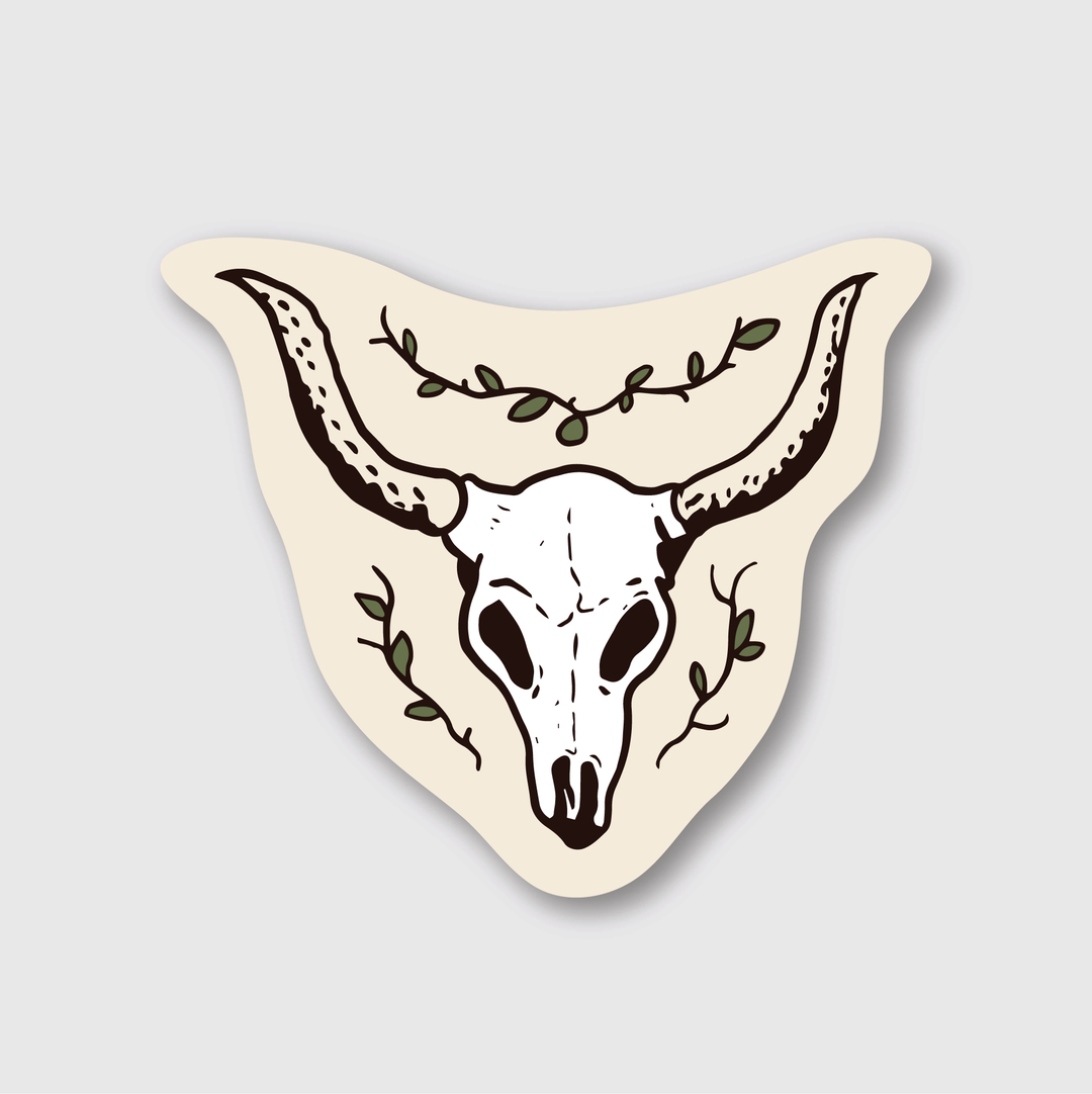 The sticker showcases a die-cut illustration of a Longhorn skull, featuring prominently extended horns. It is surrounded by green vines, all set against a beige background.