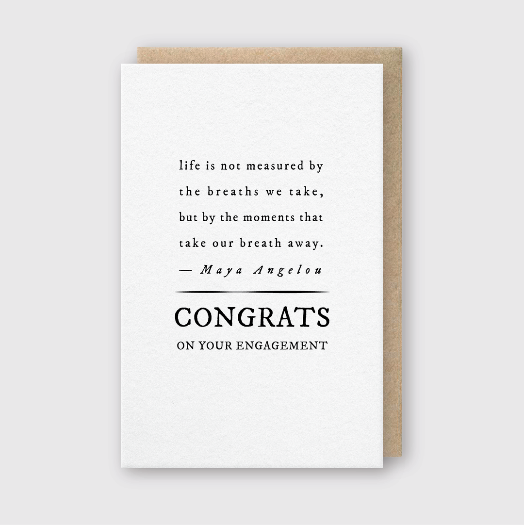 This greeting card from Pike Street Press, called the Congrats Engagement Quote Greeting Card, is designed to celebrate an engagement with a heartfelt message. It features a quote by Maya Angelou: "life is not measured by the breaths we take, but by the moments that take our breath away," and prominently displays "CONGRATS ON YOUR ENGAGEMENT" below.