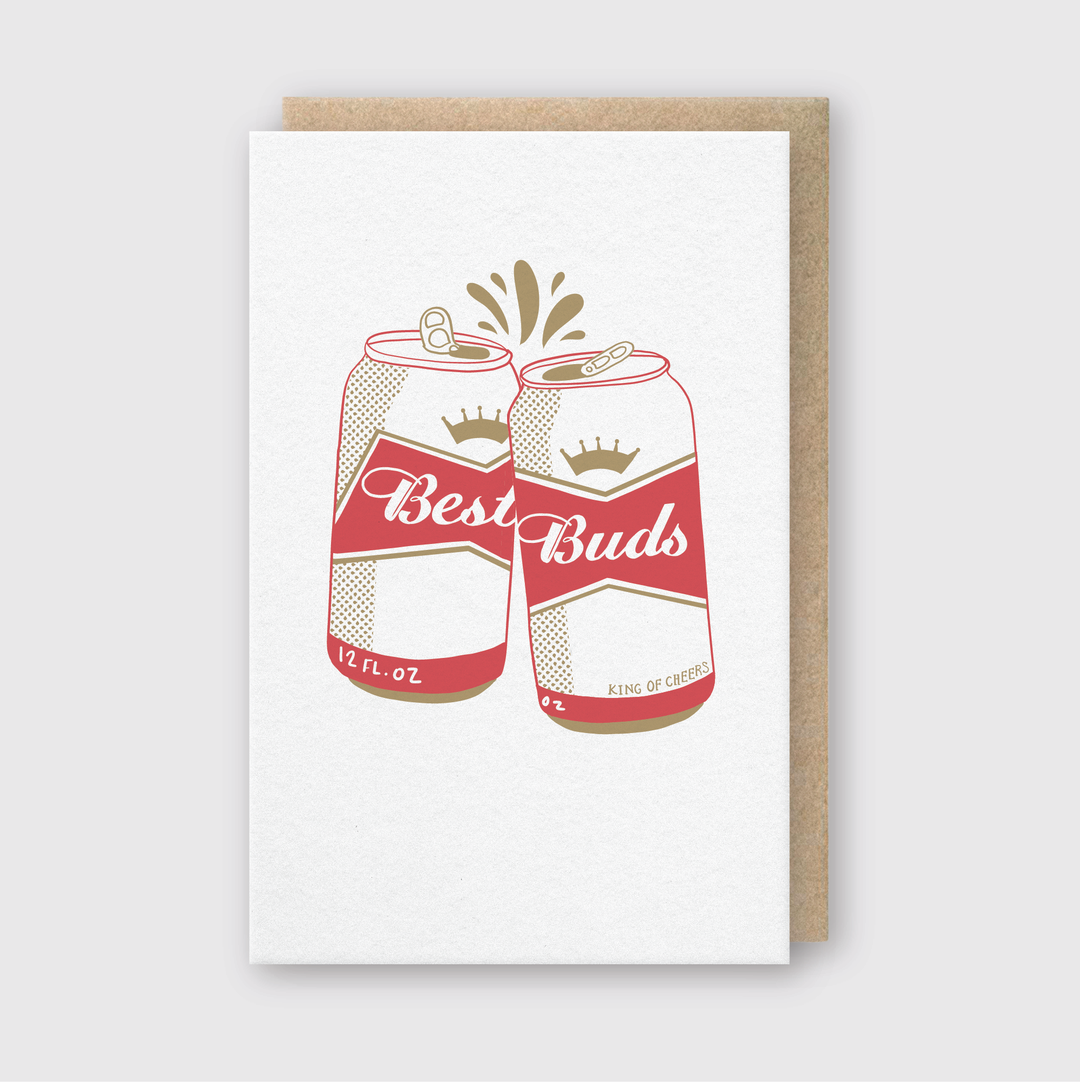 The "Best Buds Beers Greeting Card" showcases an illustration of two red and white cans clinking, creating a small splash effect. This handcrafted artwork is presented on a simple white card with a brown paper border.