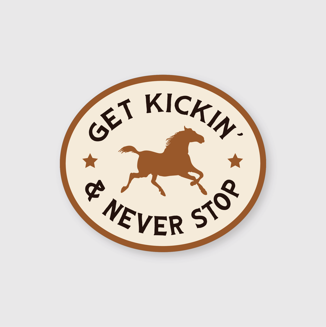 Introducing the "Get Kickin' Sticker," an oval-shaped emblem featuring a die-cut silhouette of a galloping horse at its center. The phrase “Get Kickin' & Never Stop” surrounds the horse. This sticker is crafted from weather-resistant vinyl and showcases a cream background with a brown border, adorned with two small stars for additional detail.