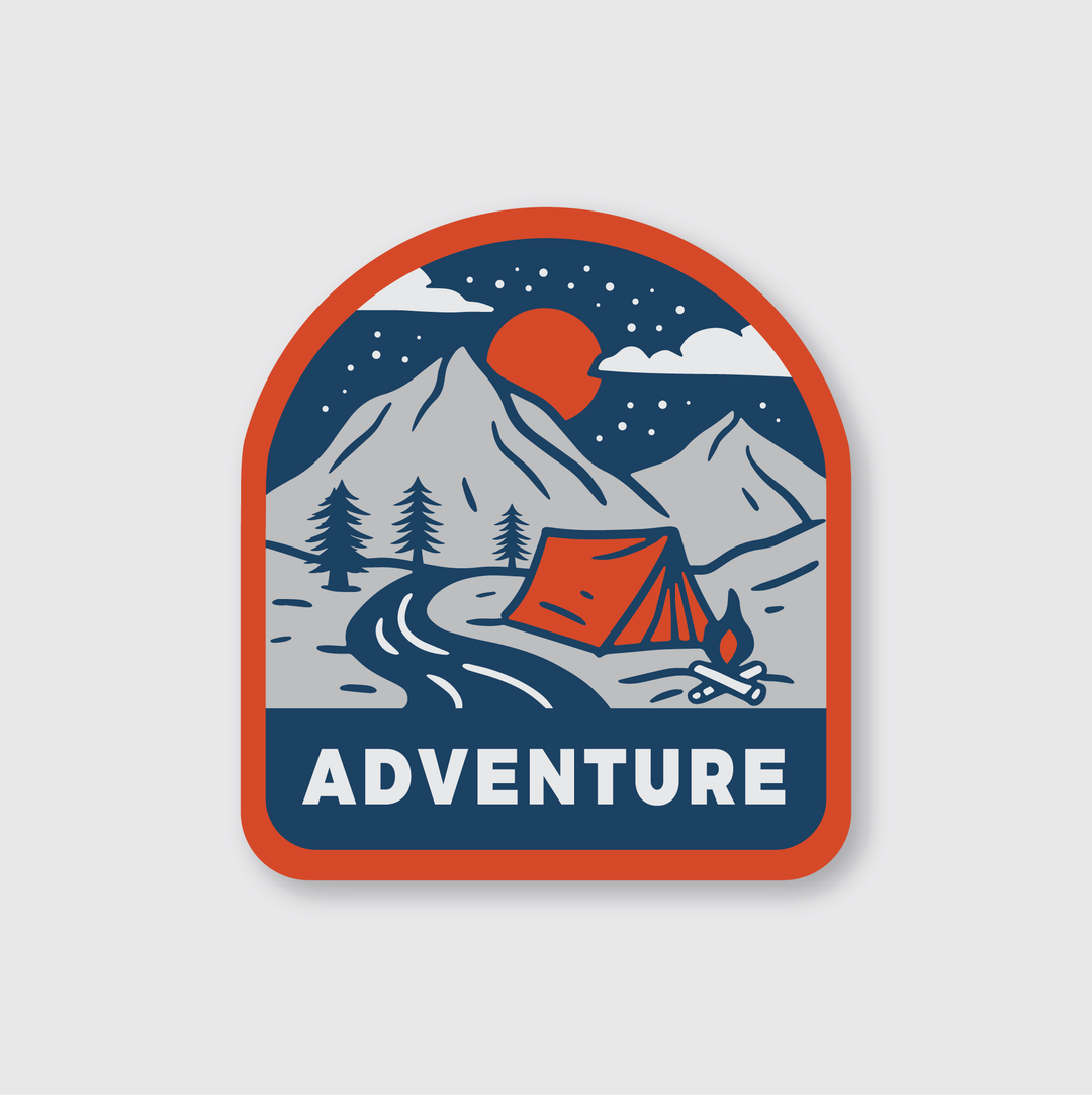 The Adventure Badge Sticker by Pike Street Press, crafted from premium weather-resistant vinyl, features an adventure-themed design with a tent beside a campfire set against a stunning mountain backdrop. A river meanders beside the tent under a star-filled night sky with a crescent moon overhead. The word "ADVENTURE" is elegantly displayed at the bottom of this die-cut vinyl sticker.