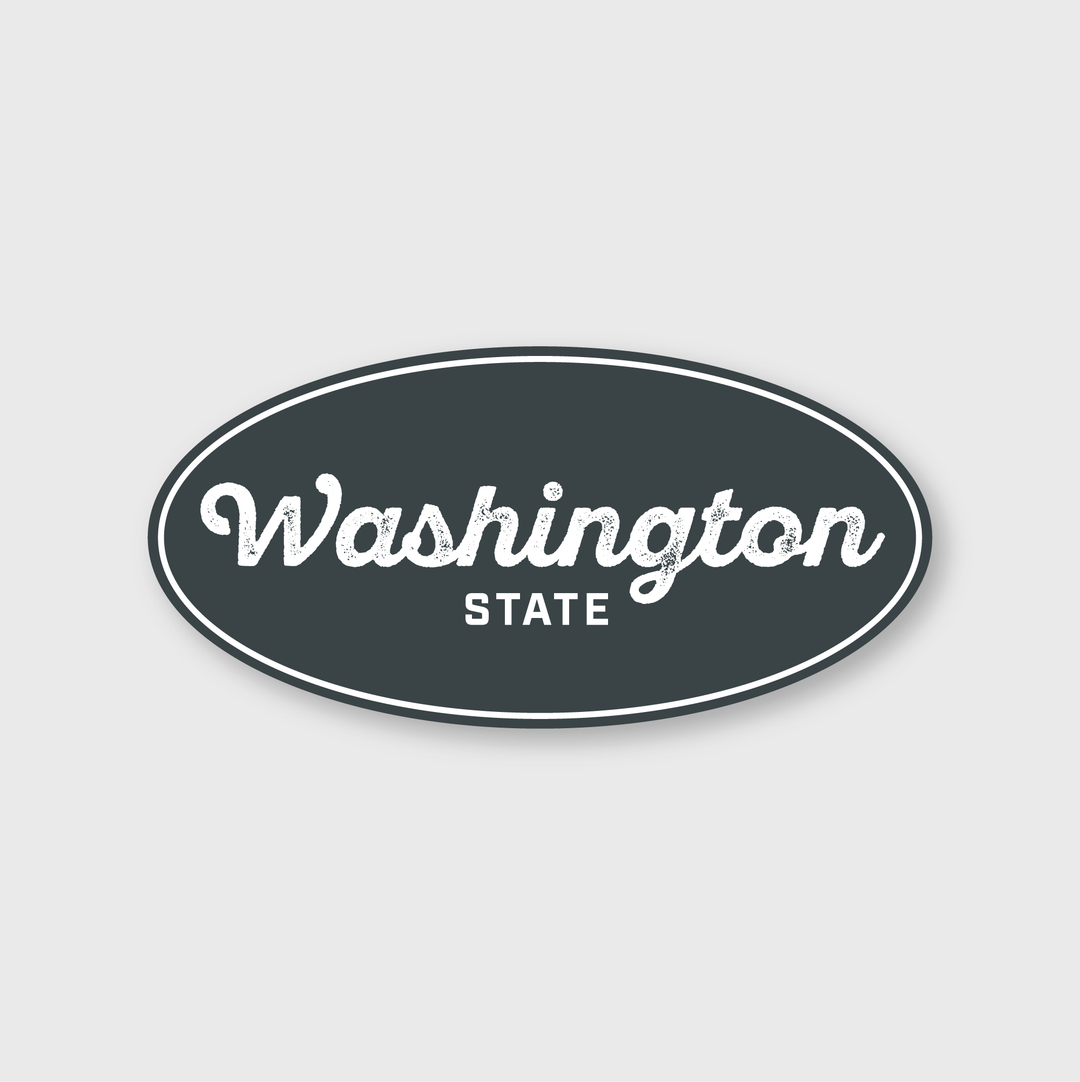 This die-cut vinyl sticker features an oval design with a dark grey background and a white border. It elegantly showcases the text "Washington State," with "Washington" in a cursive font and "STATE" in bold capital letters, capturing the essence of Washington State.