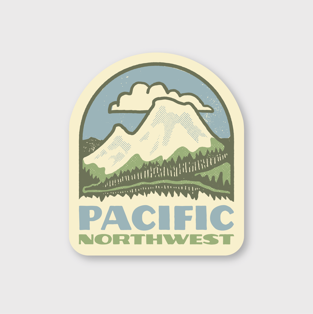 The PNW Rainier Badge Sticker features a vintage-style emblem with a mountain range, clouds above, and a forest below, capturing the essence of Seattle. "Pacific Northwest" is highlighted in bold blue letters at the bottom. The muted color palette and high-quality craftsmanship enhance its appeal.