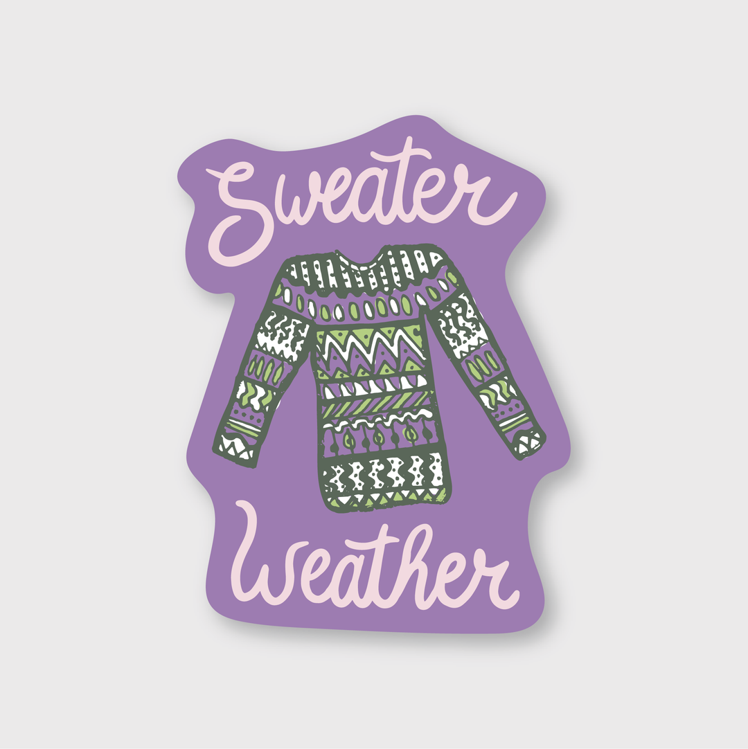 The Sweater Weather Sticker is a Die Cut Vinyl Sticker featuring a vibrant patterned sweater at its center. The words "Sweater Weather" encircle it playfully against a soft purple backdrop, making this weather-resistant gem ideal for cozy days.