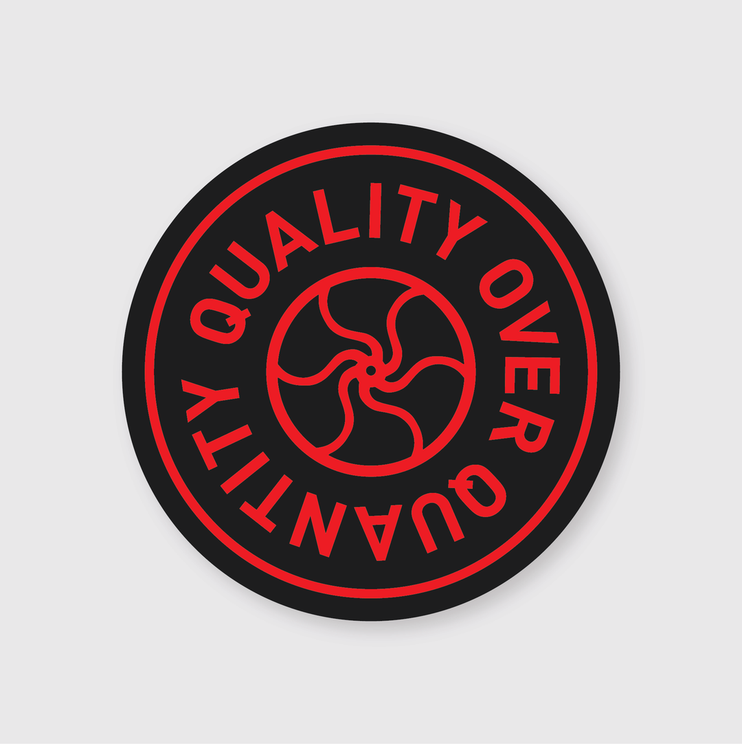 The sticker from Pike Street Press showcases a circular black design adorned with red text along the edge stating "QUALITY OVER QUANTITY." The center features a striking red spiral design, adding an extra touch of flair.