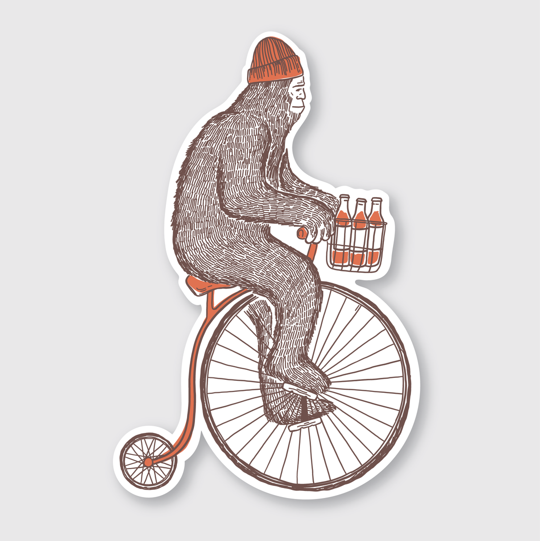 The Sasquatch Bike Sticker showcases a playful scene with a Sasquatch in a red beanie riding a vintage penny-farthing bike and carrying a six-pack of bottles in the front basket. This charming die-cut vinyl sticker is an ideal addition to your collection!