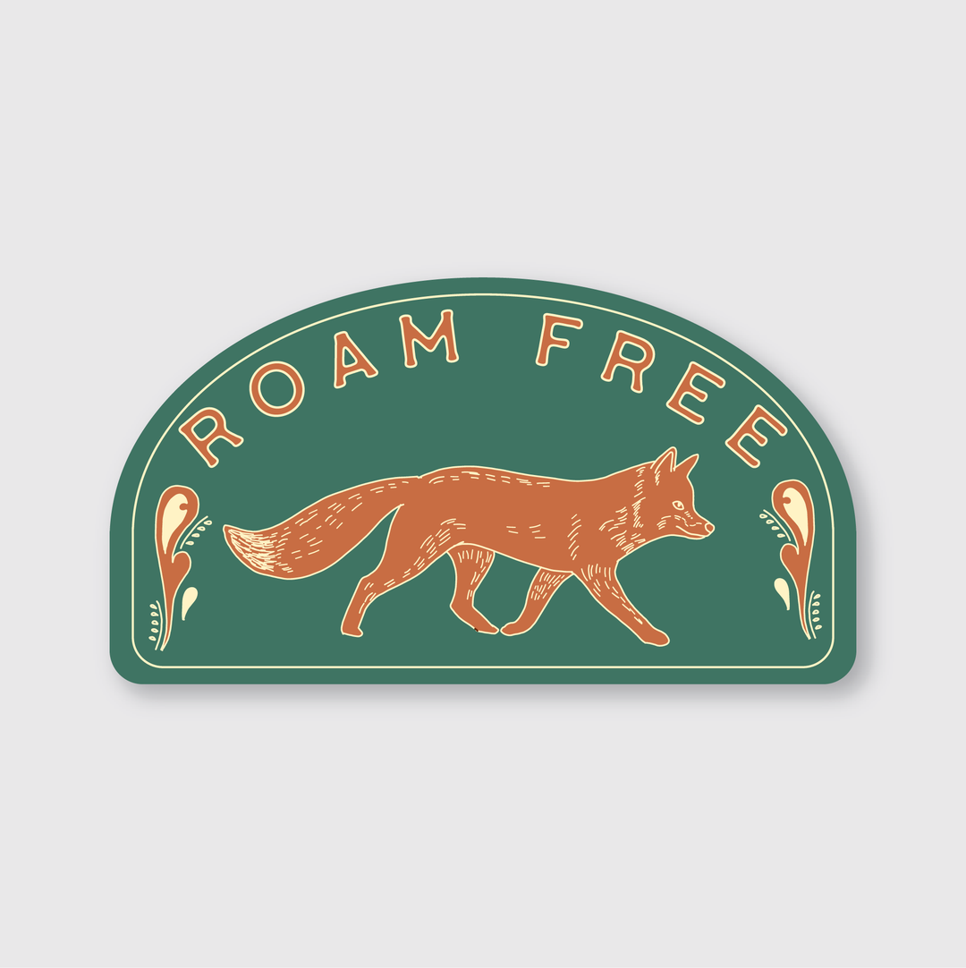 The sticker showcases a detailed illustration of a brown fox moving gracefully amidst floral patterns set against a green arched background. With the words "ROAM FREE" elegantly positioned above, it represents skilled craftsmanship and an appreciation for natural beauty. This creation by a Seattle-based artist highlights their dedication to artistry and meticulous attention to detail.